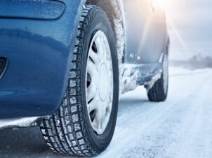 Vinterhjul på blå bil i snøen