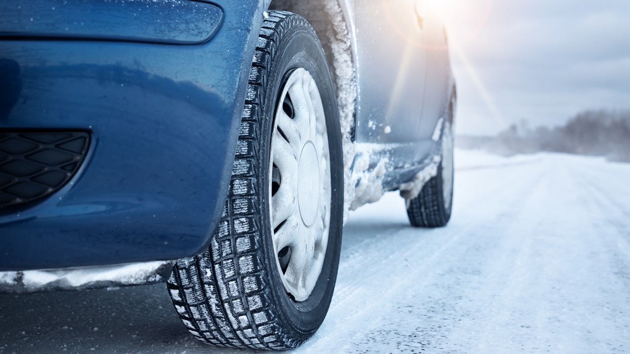 Vinterhjul på blå bil i snøen