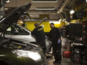 2 mekanikere jobber på en bil inne på et Mekonomen verksted