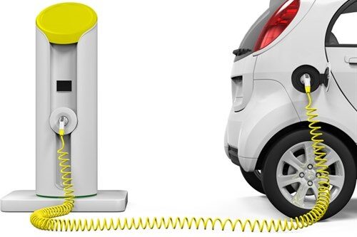 Hvit bil med gul elbil ladeledning og lader