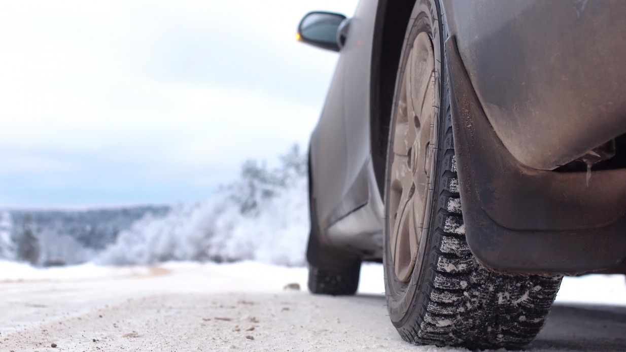 Vinterdekk på mørk bil på snødekt vei