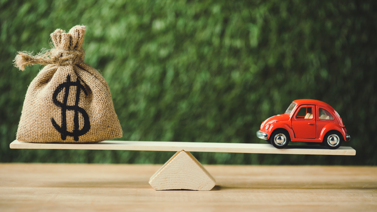 Vippehuske med en liten rød bil på ene siden og en stor pengesekk på andre siden