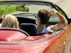 Sommerbilen er klar for sesongen, 3 ungdommer koser seg i en rød cabriolet