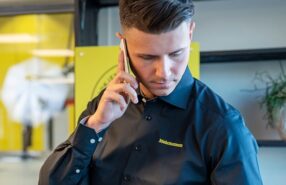 Mann med svart Mekonomen skjorte prater i telefonen